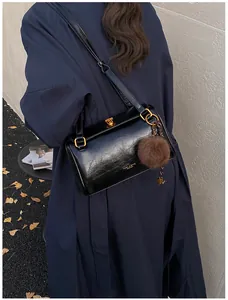 Détails du sac oreiller en cuir ciré noir avec fermoir doré et charme en peluche