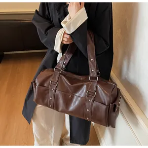 Detail of dark brown vintage travel bag with silver studs and matte PU leather texture