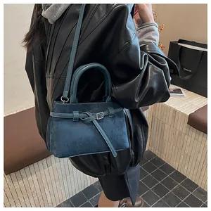 Nahaufnahme der dunkelblauen Wildleder-Beuteltasche mit Lederknoten und Metallschließe