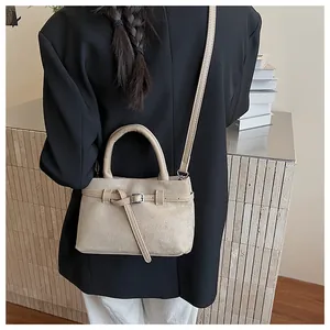 Detailansicht der khakifarbenen Beuteltasche aus Wildleder an einem professionellen Model