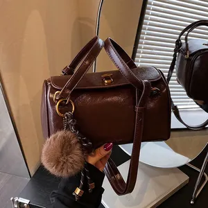 Sac Boston Rétro en Cuir PU Brillant pour Femme Sac à Bandoulière Cylindre Avec Serrure Métallique Dorée Et Pendentif Boule de Poils Sac Oreiller Élégant