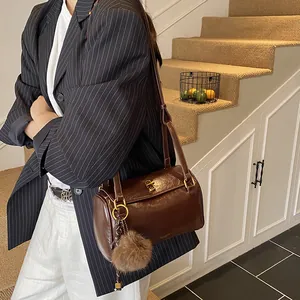 Sac cylindrique rétro marron foncé avec fermoir doré et pompon en fourrure doux