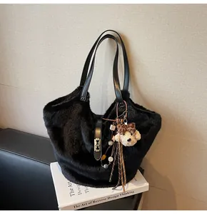 Détail d'un sac cabas noir en fausse fourrure avec bandoulière en cuir et charm ours léopard