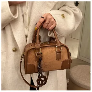 Détail du sac Boston marron avec gaufrage ATN et pendentif en forme de cœur