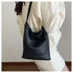 Vue détaillée du sac bandoulière noir en cuir grainé porté par un mannequin en gros plan