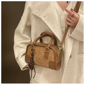 Détail du sac Boston marron avec chaîne, textures suédées et logo GEN PIN embossé