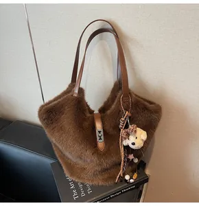 Détail du sac cabas en fausse fourrure marron avec fermoir argenté et breloque ours