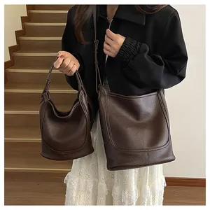 Détails de deux sacs à main en cuir marron foncé avec motif litchi en grandes et petites tailles