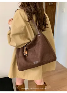Close-up of deep brown suede tote bag featuring retro wooden beads and metal ring detail