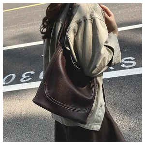 Vue de rue du sac cabas marron foncé motif litchi avec une tenue d'automne décontractée