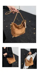 Détail du sac hobo en daim marron avec bandoulière tressée et décorations d'automne