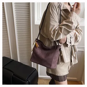 Grand sac bandoulière en daim avec perles décoratives en bois et blanc en détail