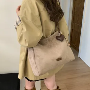 Minimalist large brown suede tote bag with heart charm shown on model for daily commute