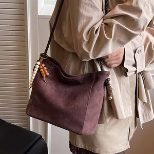 Grand sac cabas en daim marron foncé avec bandoulière tressée et pompon en bois