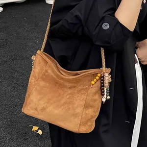 Grand sac seau en daim marron avec bandoulière tissée et pendentif perlé rétro