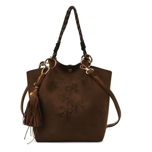 Braune Wildleder-Eimertasche mit Perlenbogen, Webgriffen und dekorativer Fransenquaste