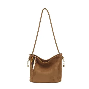 Sac seau en daim marron avec bandoulière tissée et pendentif à pompon coloré