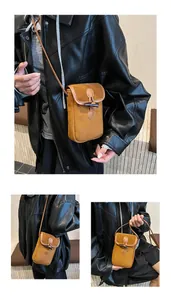 Detail of brown suede crossbody bag with vintage toggle closure and leather strap