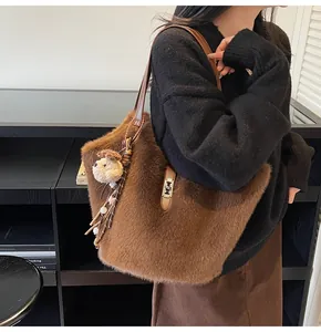 Détail d'un sac cabas en peluche marron avec fermoir métallique et breloque agneau