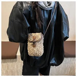 Close-up of contrast faux fur crossbody bag featuring brown leather trim and strap