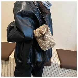 Detail showing the retro tweed texture and brown leather trim of the crossbody bag