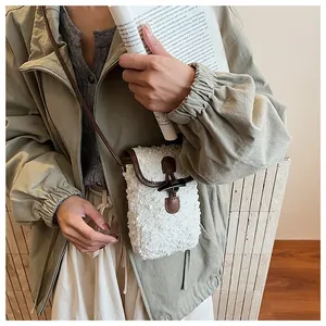 Detail of plush faux fur crossbody bag with leather trim and wooden horn button closure