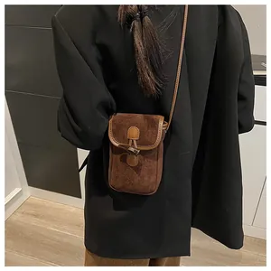 Macro shot of faux suede crossbody bag with vintage horn buckle and leather strap