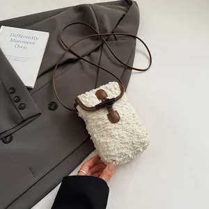 Close-up of fuzzy faux shearling bag with contrast leather trim and horn buckle detail