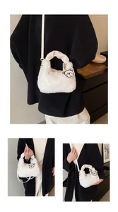 Détail du sac à main en fausse fourrure blanche avec poignée froncée et breloque ours