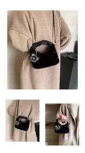 Détail du sac bandoulière en peluche avec poignée en cuir et breloque ours blanc