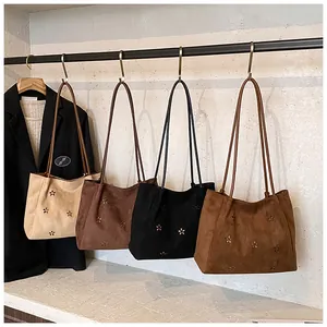 Detailed laser-cut floral patterns on suede tote bags in four classic colors