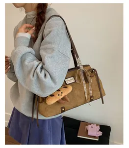 Dettaglio della borsa tote marrone vintage con stampa gatto, foulard e charm biscotto