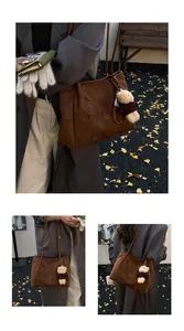 Detail of suede tote bag with laser-cut floral patterns and cute teddy bear charm