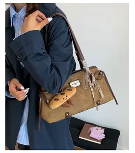 Dettaglio della borsa tote vintage con gatto goffrato, nastro e ciondolo a forma di pane