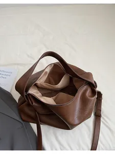 Vista interior del bolso tote marrón con forro de tela espacioso y detalle de bolsillo