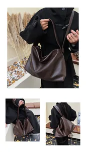Bolso hobo grande café oscuro combinado con abrigo negro para un look de otoño