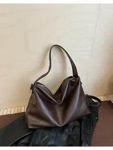 Vista de detalle del bolso tote grande marrón oscuro con textura suave y cremallera