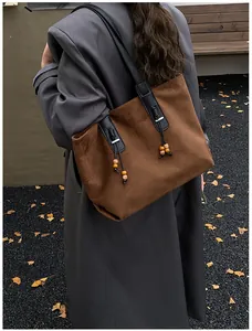 Dettaglio borsa tote vintage in pelle scamosciata marrone scuro con coulisse e perline