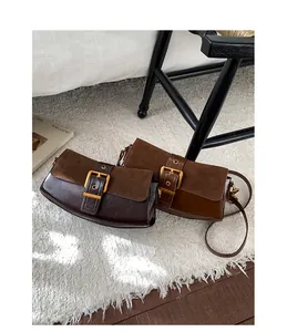 Detailed close-up of retro suede patchwork underarm bags with stylish metal buckles