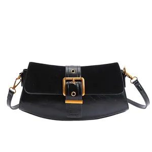 Close-up of black leather underarm bag featuring a golden square buckle and suede texture