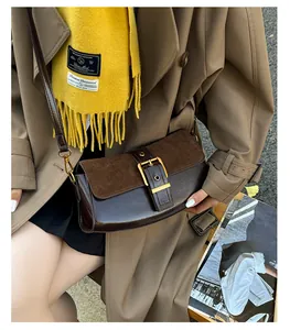 Detail of vintage brown leather underarm bag with gold buckle and adjustable strap