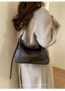 Détail du sac sous le bras marron foncé rétro avec coutures contrastées sur manteau