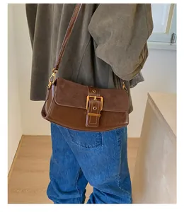 Detail view of dark brown vintage underarm bag with metal buckle on leather strap