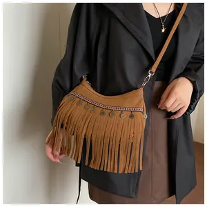 Détail du sac à bandoulière marron à franges avec tresse ethnique et pièces métalliques