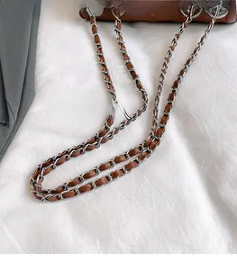 Detail des Umhängetaschen-Riemens mit silberner Metallkette und braunem Leder