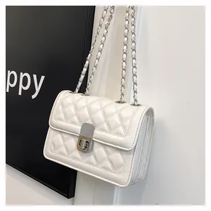 Detail der weißen Stepptasche mit silberner Kette und seitlicher Akkordeon-Struktur
