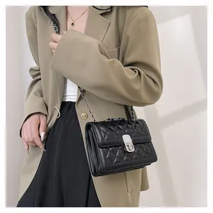 Detailaufnahme der schwarzen Stepptasche mit silbernem Metallschloss und Kettengurt