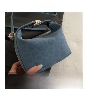 Close-up of fog blue tote bag with leopard texture and golden metallic buckle