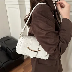 Borsa a sella bianca con trama coccodrillo e fibbia dorata indossata dal modello