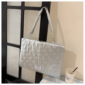 Silver quilted laptop sleeve featuring 3D bow patterns and a fashion label design